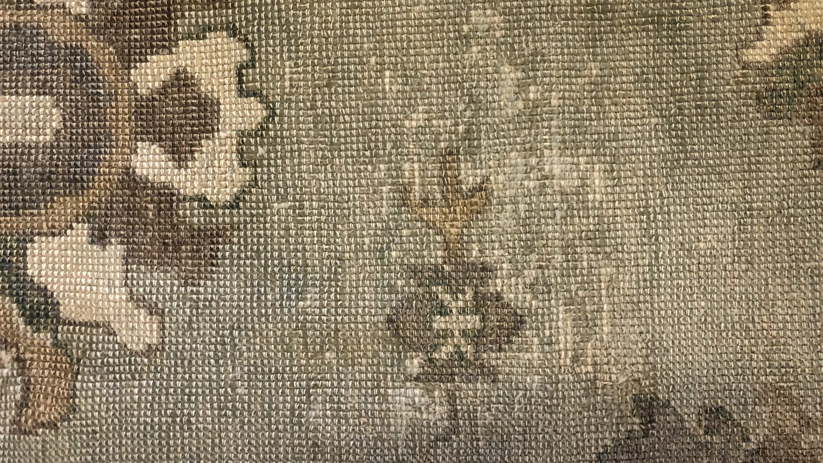 The reverse of a wool rug, where damp damage in the cotton foundation shows before the pile gives it away