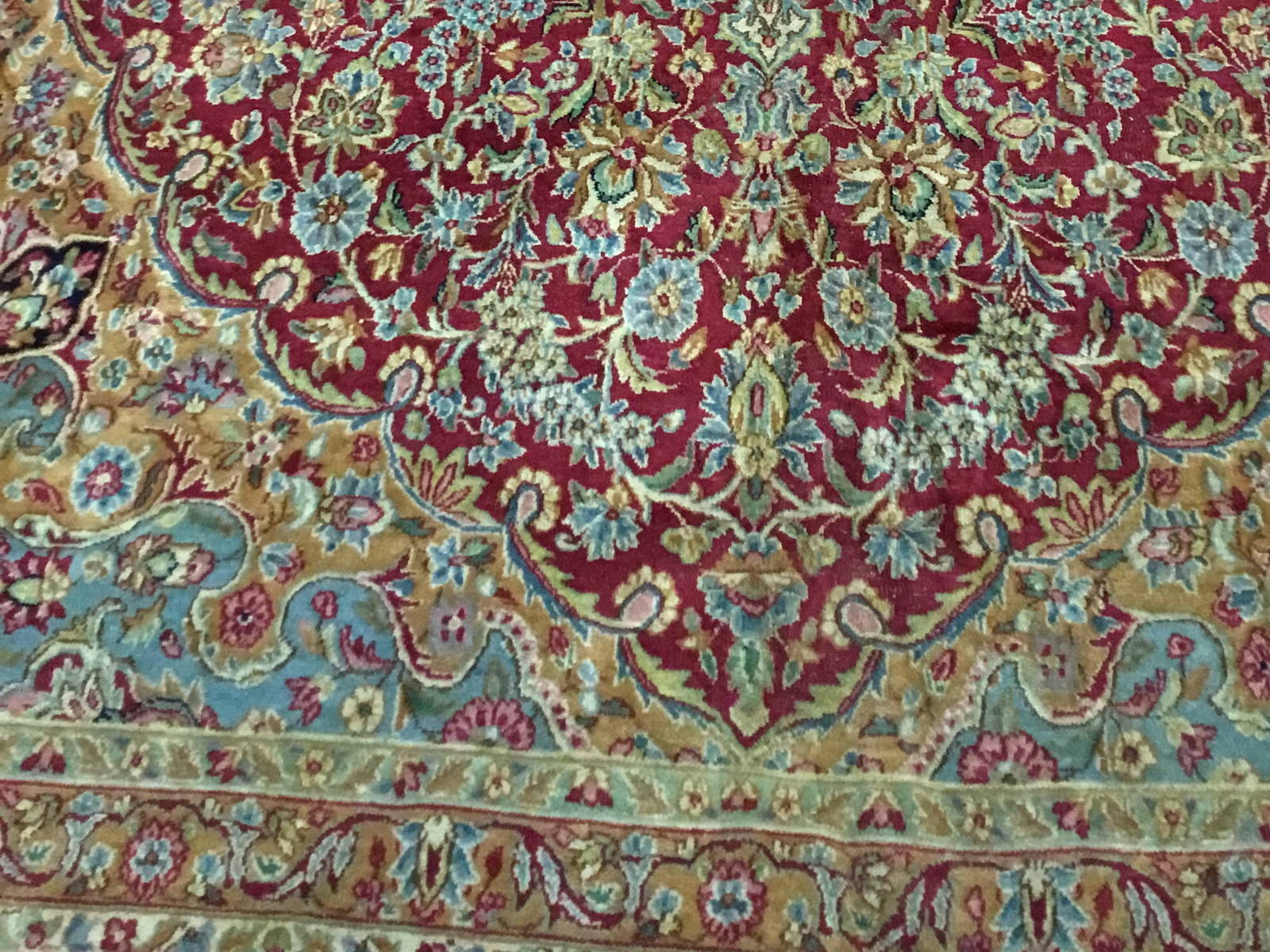Field meeting border on the same rug before cleaning, the blues and pinks greyed and indistinct
