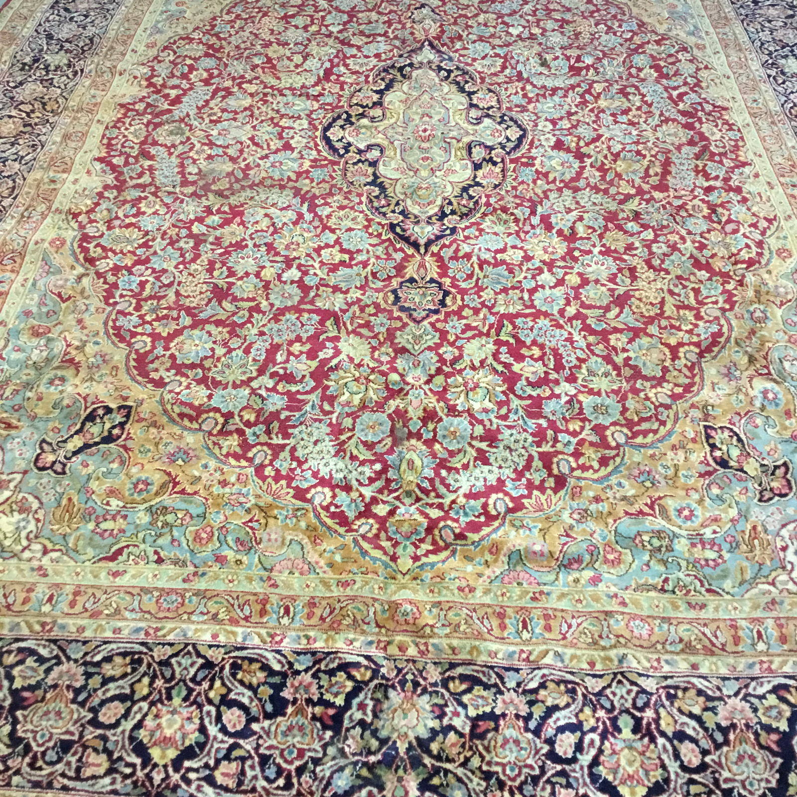 Centre of the same rug before cleaning, the navy medallion and red field hazy and low in contrast